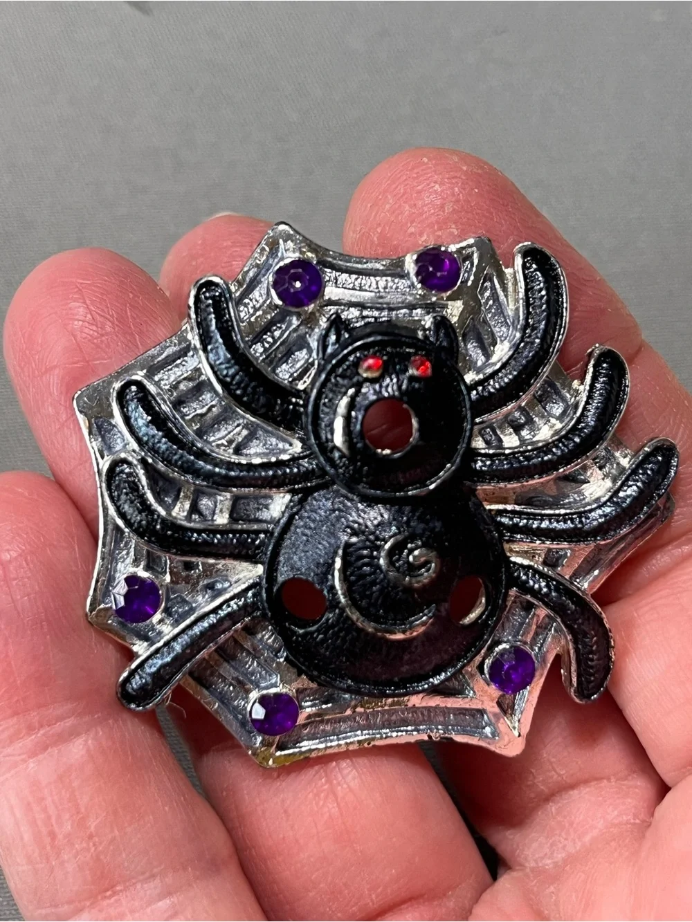 Spooky silver and black metal spider pin for Halloween.